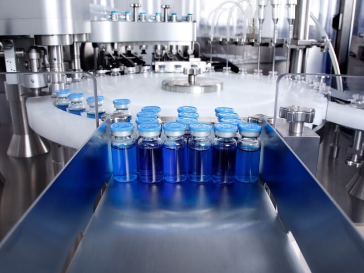 Prüfung auf extrahierbare und auslaugbare Stoffe bei Fläschchen, die mit einer blauen pharmazeutischen Flüssigkeit gefüllt sind, in einer Produktionsanlage